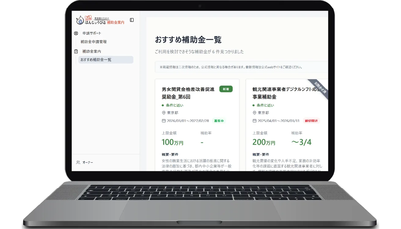 ノートパソコンの画面に補助金一覧ページが表示され、複数の支援制度が見やすく並んでいる。